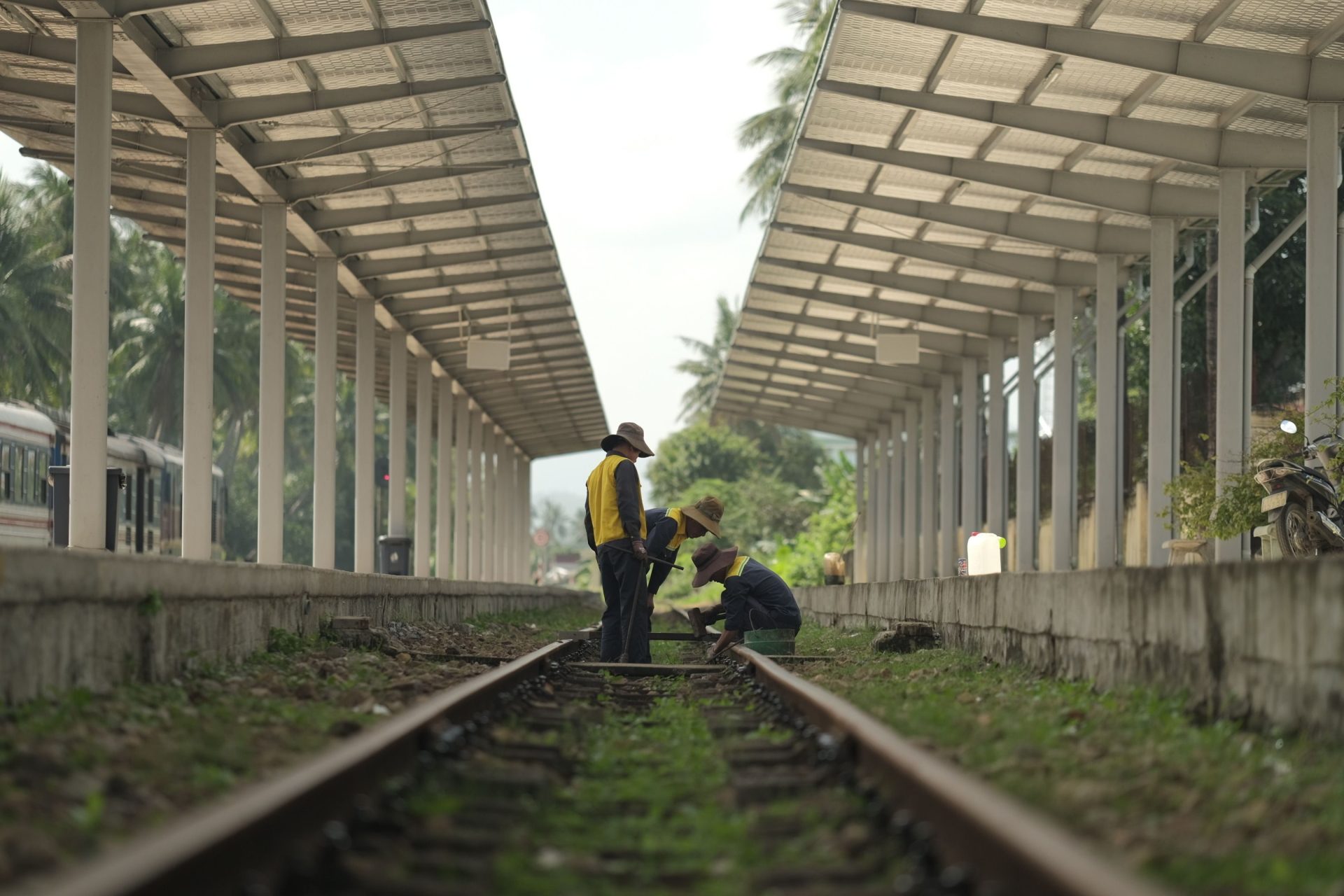 Arbeiter bei der Instandhaltung von Bahngleisen an einem ländlichen Außenbahnhof.