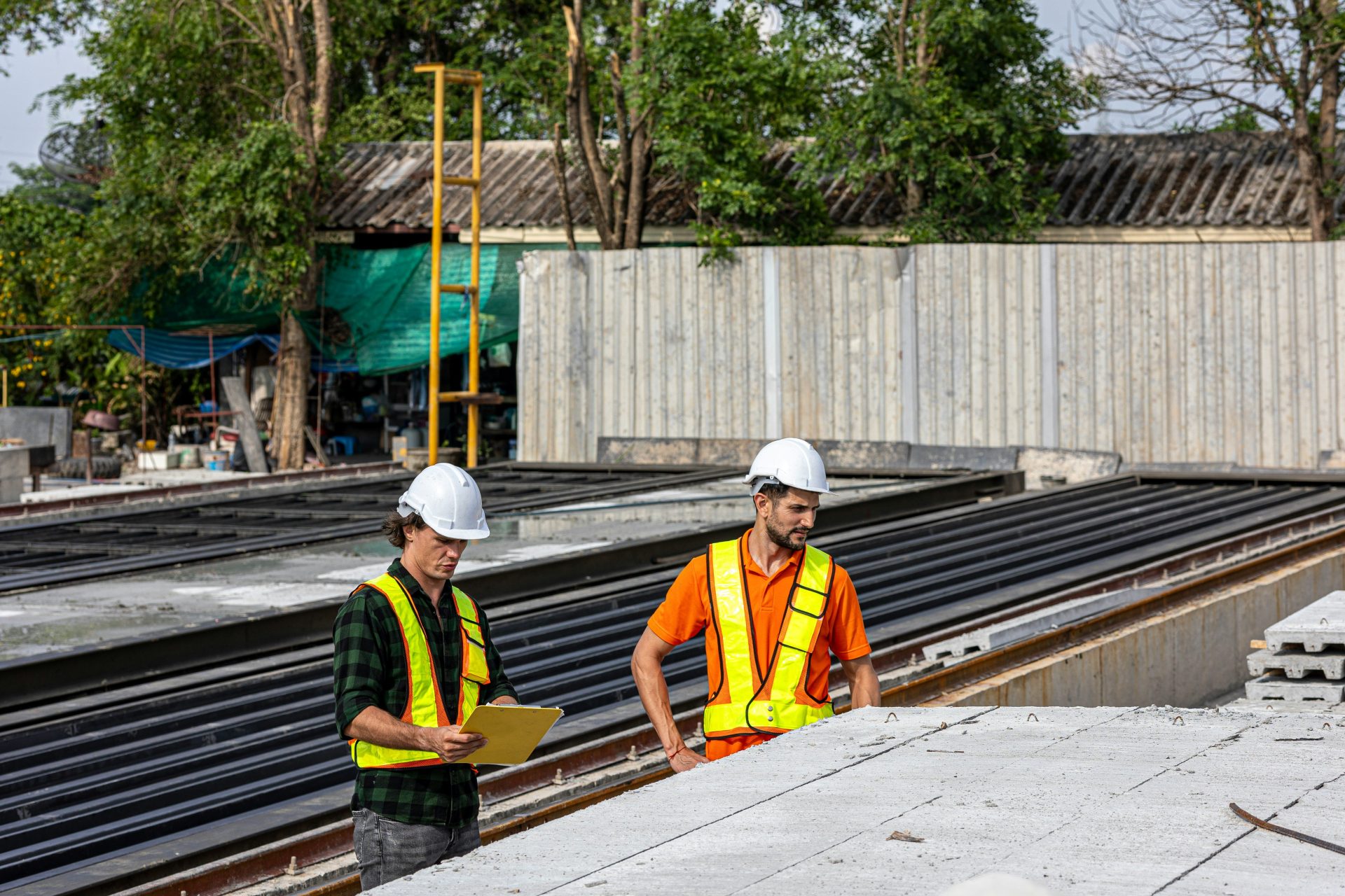 Bauarbeiter prüfen Pläne auf einer Baustelle.